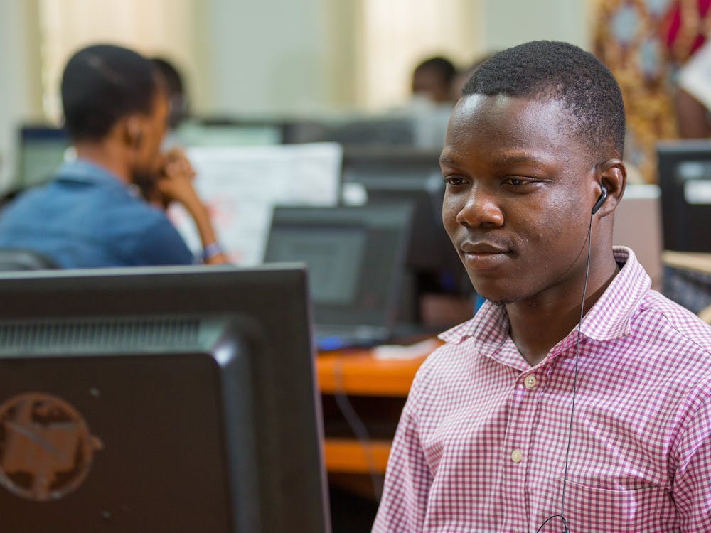 Junger Mann aus Ghana vor einem Computer Bildschirm