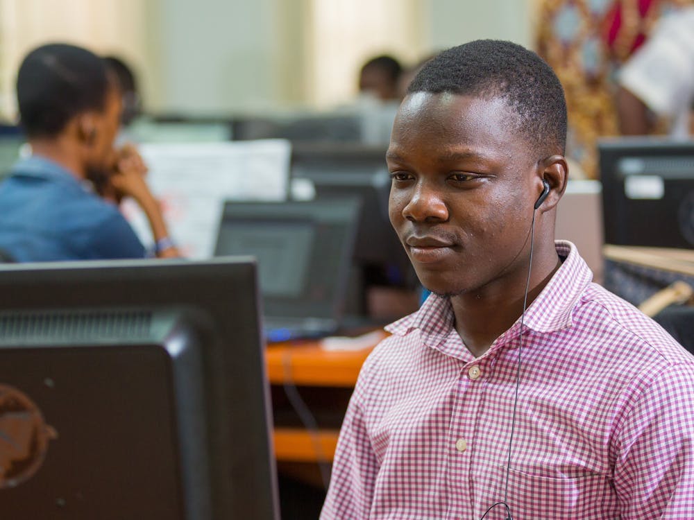 Junger Mann aus Ghana vor einem Computer Bildschirm